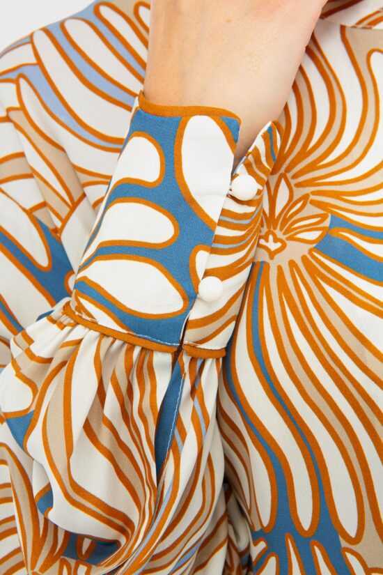 IVI collection SWIRL hochwertige Seidenbluse in den Farben hellblau und beige aus der Resort25 Kollektion. IVI collection SWIRL high-quality silk blouse in the colors light blue and beige from the Resort25 collection.